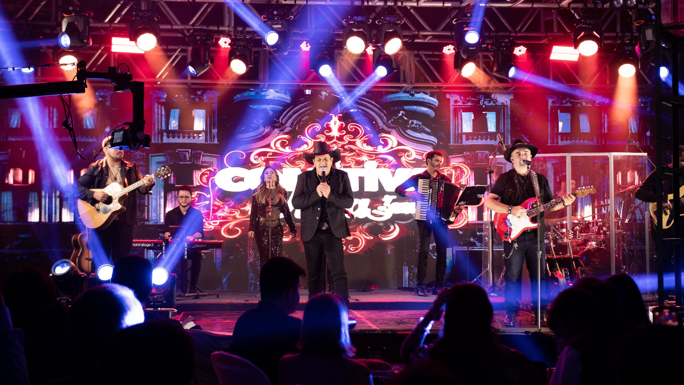 Comitiva da Viola Show no palco com a banda completa e o público